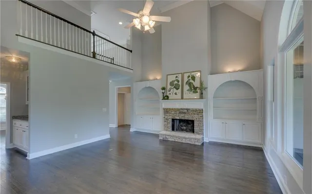 a living room with wooden floor and a fireplace