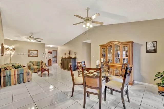 a dining room with furniture and chandelier fan