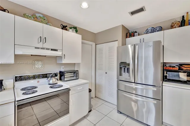 a kitchen with stainless steel appliances granite countertop a refrigerator sink stove and cabinets