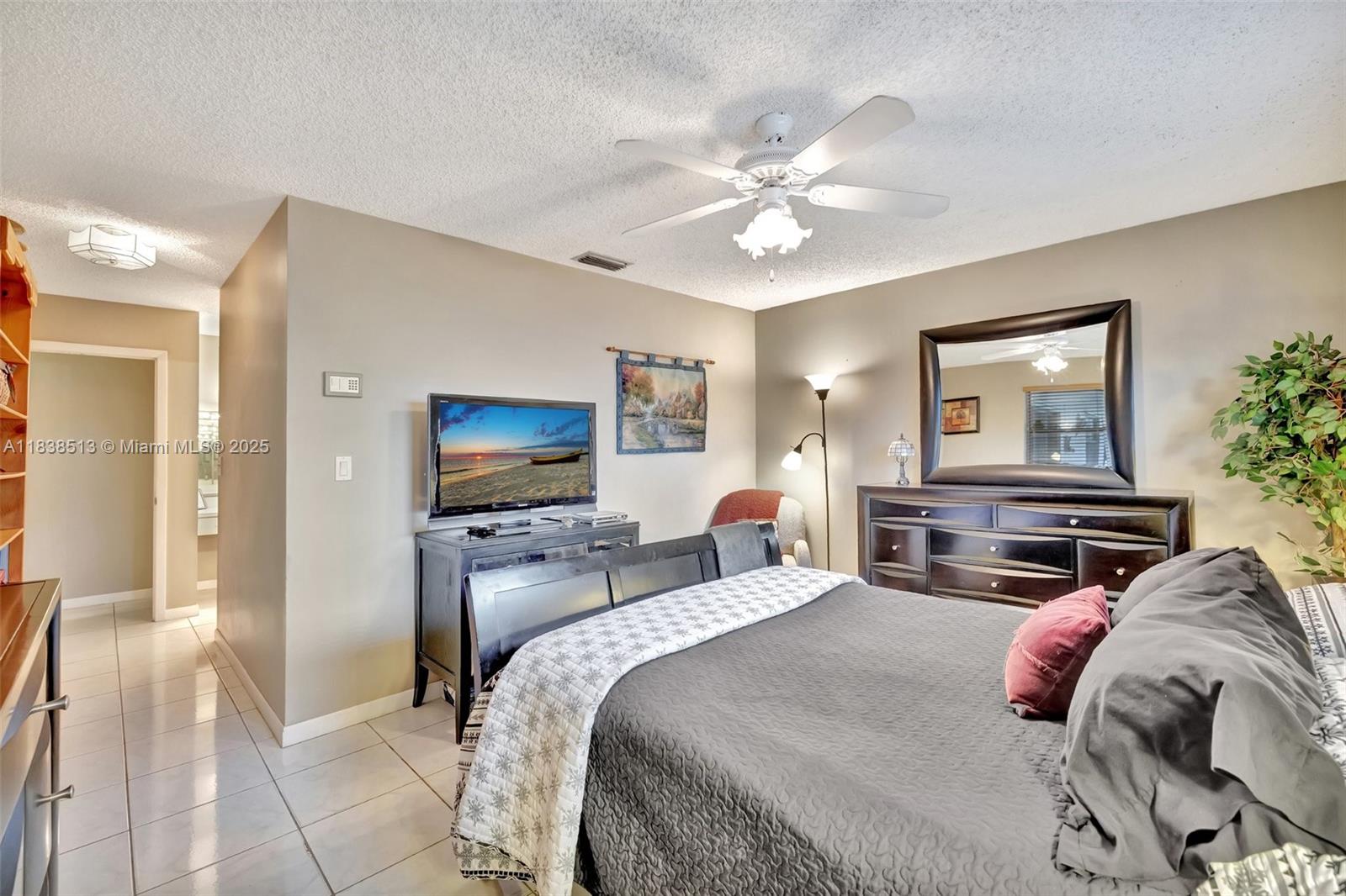 5911 Epsom Court Davie, FL 33331 - Photo 21 of 38 a bedroom with a bed and a chandelier