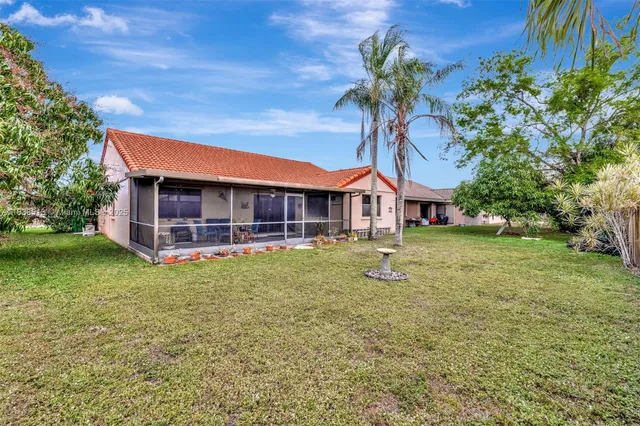 a view of a house with a small yard and palm trees