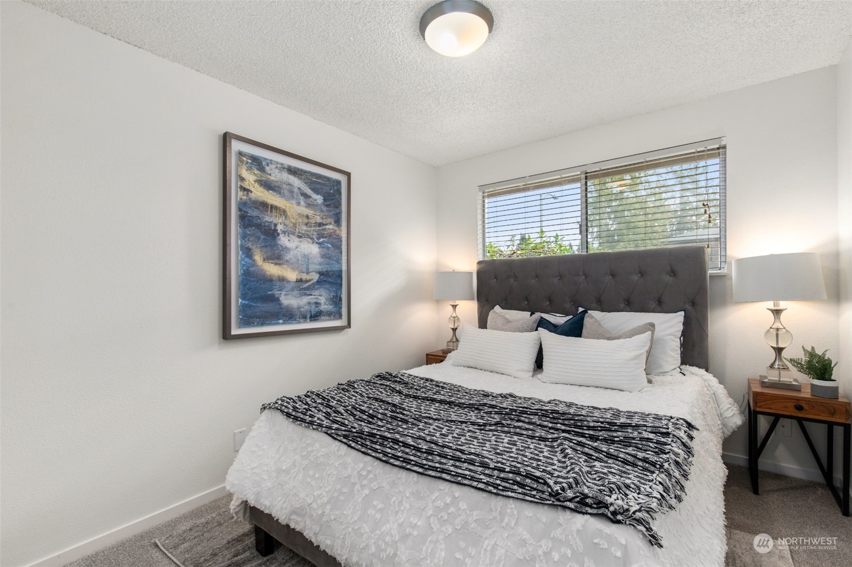 22700 1st Place West Bothell, WA 98021 - Photo 15 of 32 a bedroom with a large bed and a lamp on dresser
