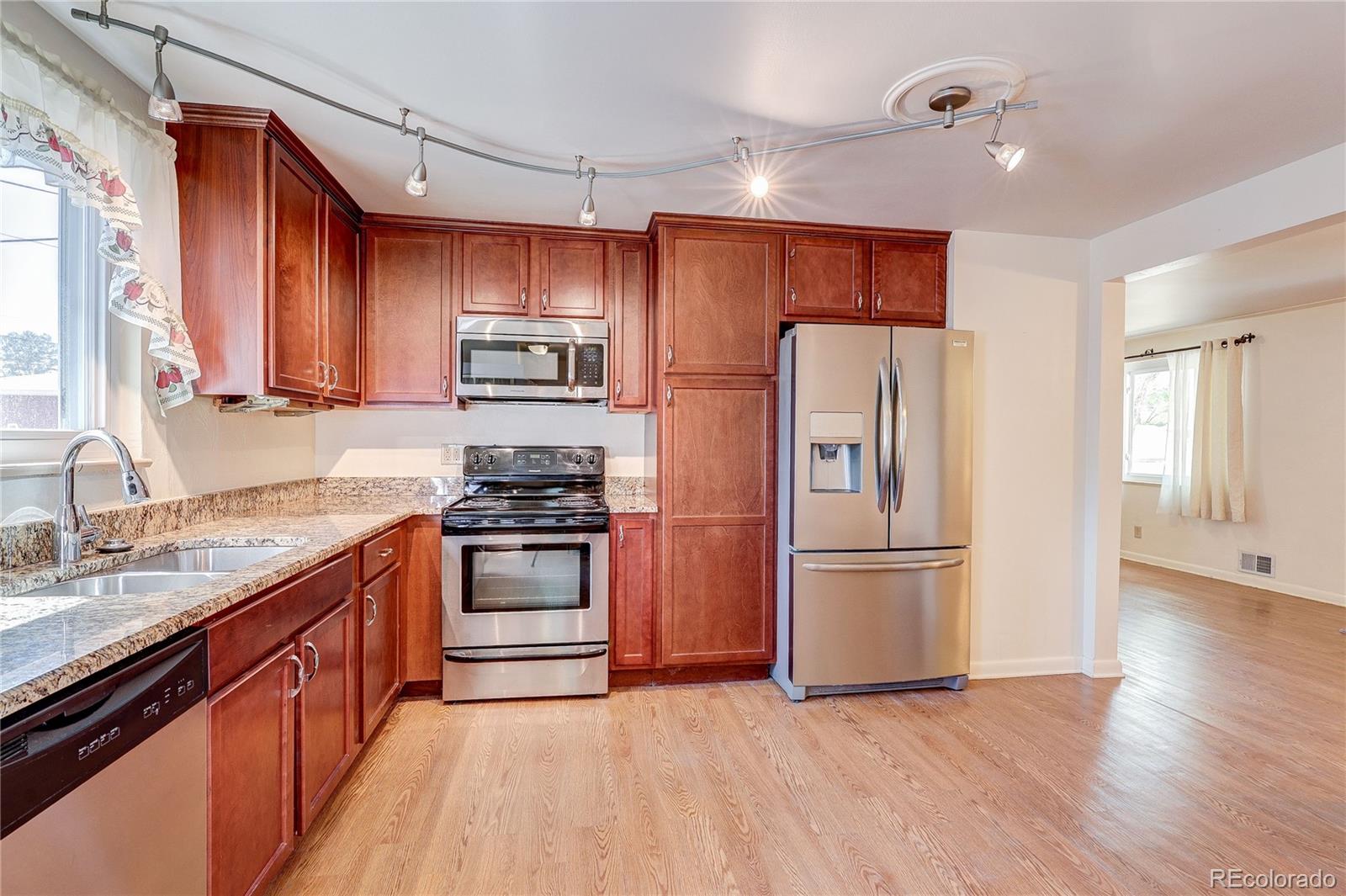 4570 Field Street Wheat Ridge, CO 80033 - Photo 13 of 44 a kitchen with stainless steel appliances granite countertop a refrigerator stove and sink