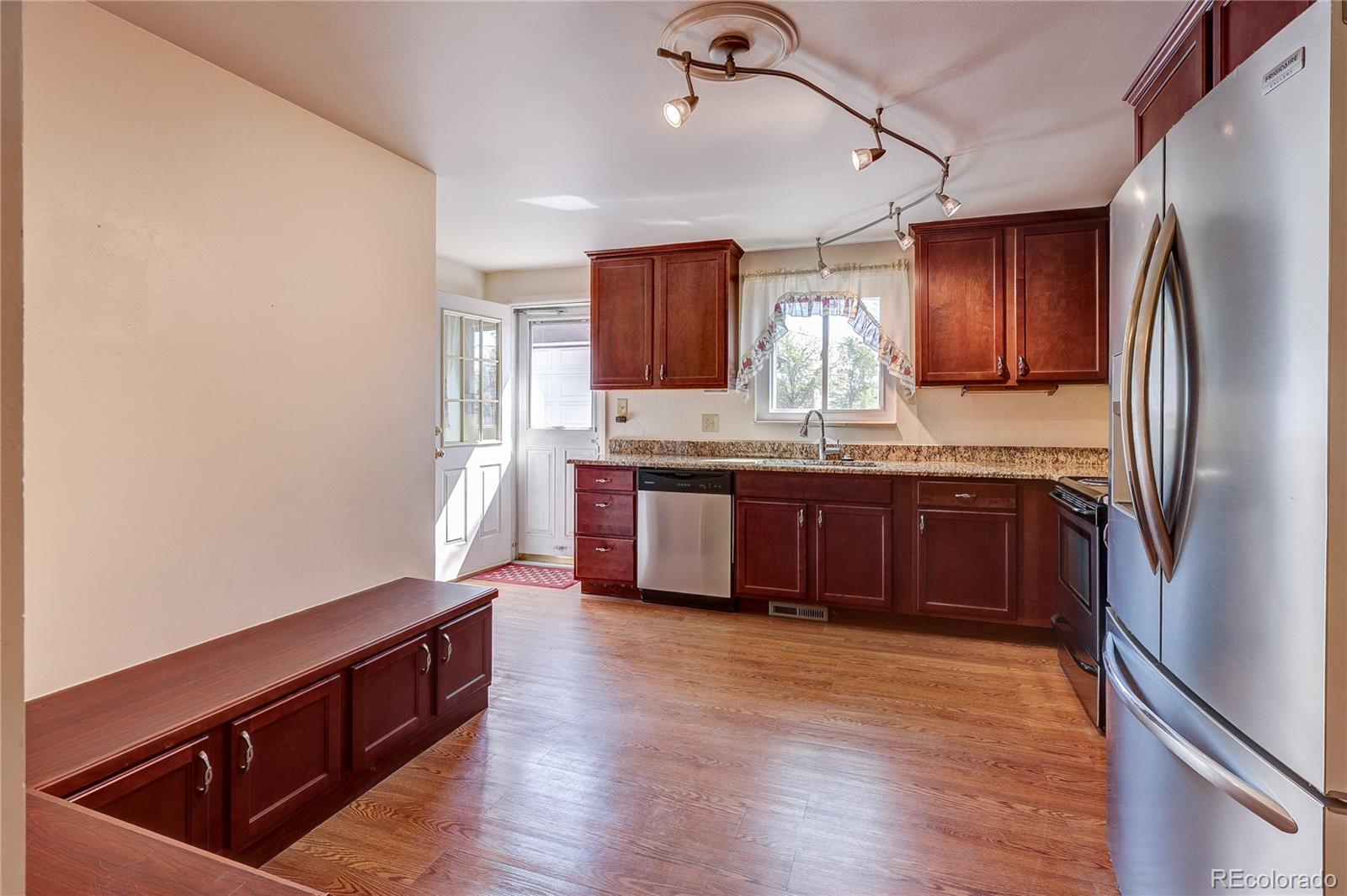 4570 Field Street Wheat Ridge, CO 80033 - Photo 15 of 44 a kitchen with stainless steel appliances granite countertop a refrigerator a sink dishwasher a stove and white countertops with wooden floor