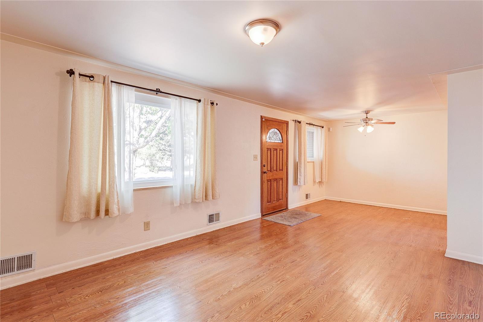 4570 Field Street Wheat Ridge, CO 80033 - Photo 7 of 44 an empty room with wooden floor and windows