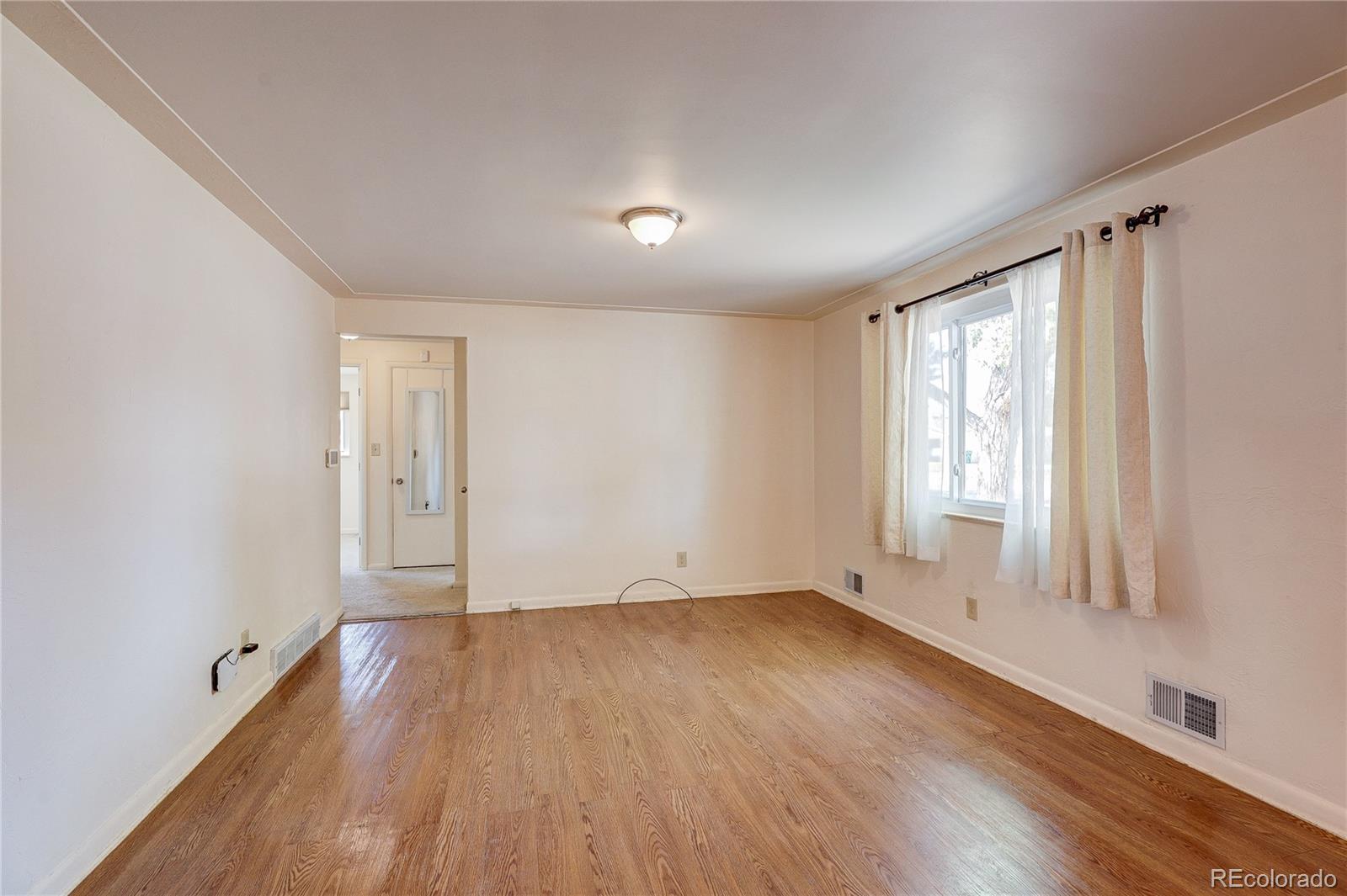 4570 Field Street Wheat Ridge, CO 80033 - Photo 10 of 44 an empty room with wooden floor and windows