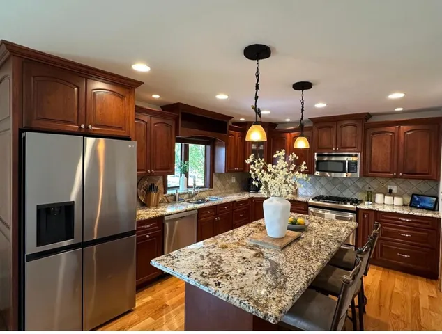 a kitchen with a refrigerator and a stove top oven