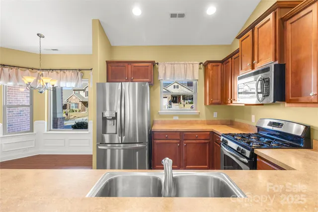 a kitchen with stainless steel appliances a stove a refrigerator and a sink