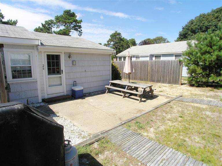 26 Edwards Road Dennis Port, MA 02639 - Photo 2 of 14 a backyard of a house with barbeque oven and outdoor seating