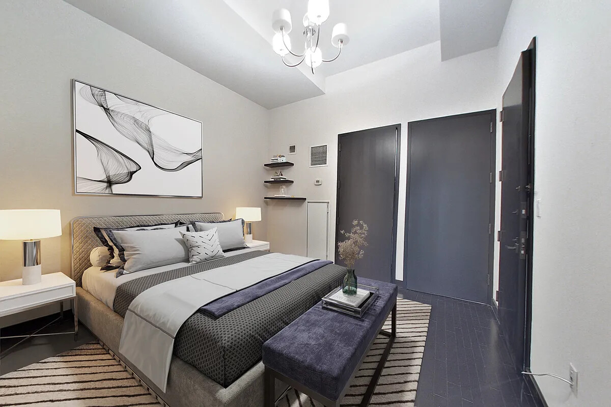 20 Pine Street, Unit 910 Manhattan, NY 10005 - Photo 6 of 17 a bedroom with bed and a chandelier