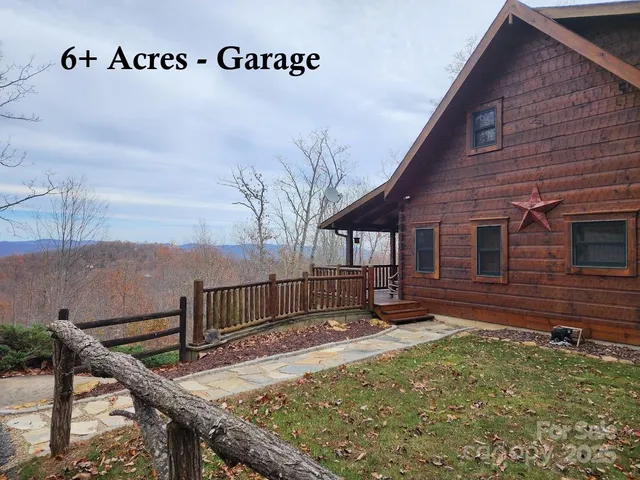 a view of a house with a yard and large trees