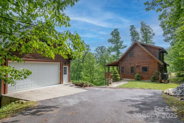 a view of a house with a yard and large trees