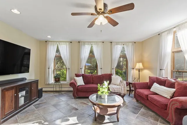 a living room with furniture a flat screen tv and a large window