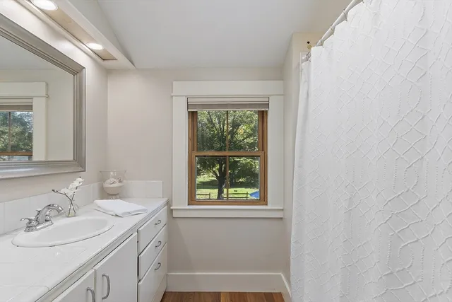 a bathroom with a sink vanity granite toilet and a window