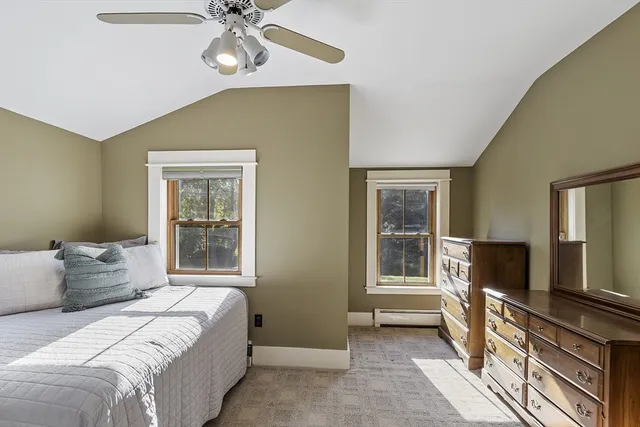 a bedroom with a bed and a flat tv screen on dresser