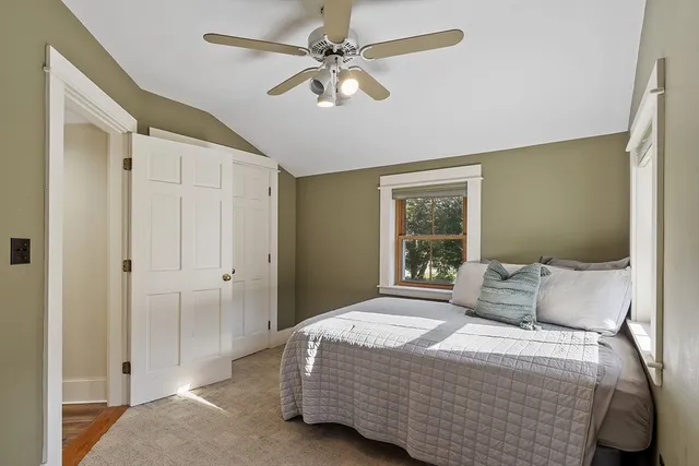 a bedroom with a bed a window and a chandelier