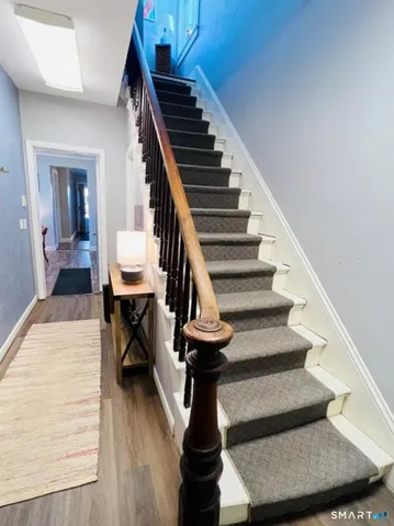 a view of entryway and hall with wooden floor