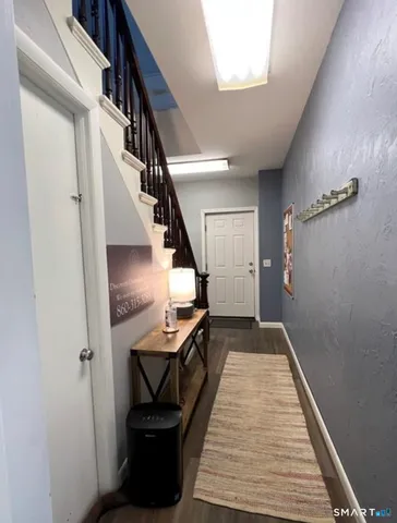 a view of entryway and hall with wooden floor