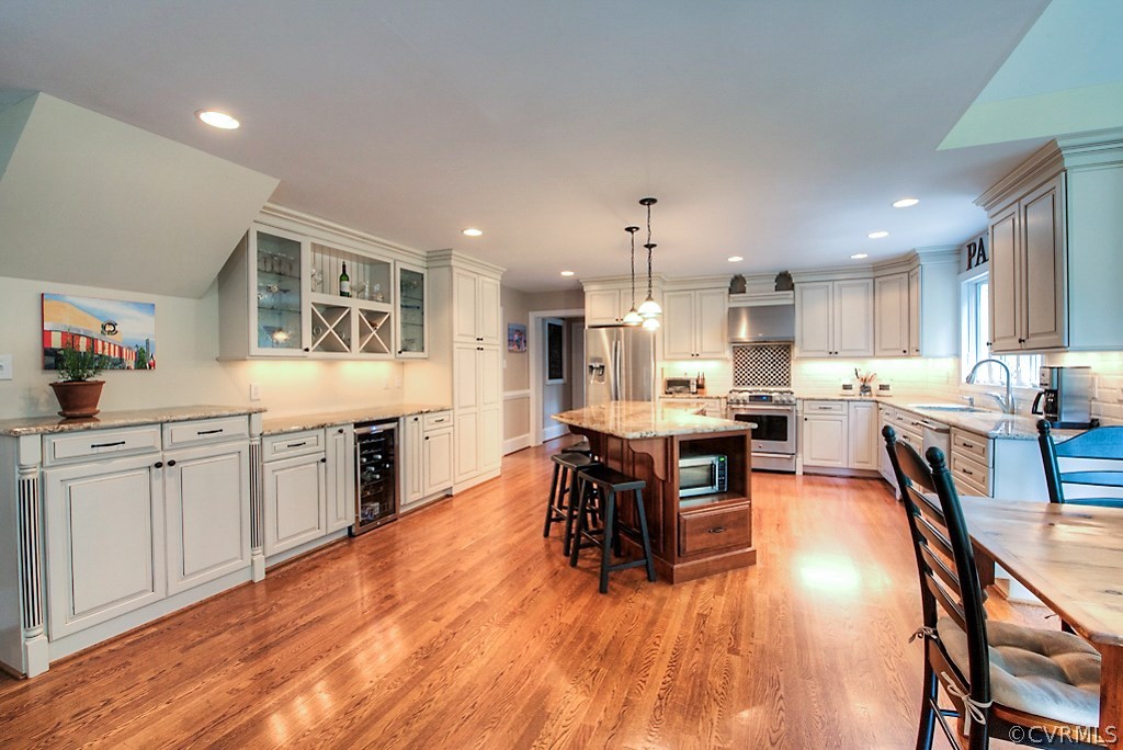 2600 Arrandell Road Midlothian, VA 23113 - Photo 16 of 45 a kitchen with stainless steel appliances granite countertop a stove top oven a sink a dining table and chairs with wooden floor