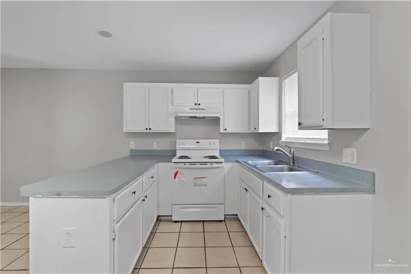 a kitchen with a sink stove and cabinets
