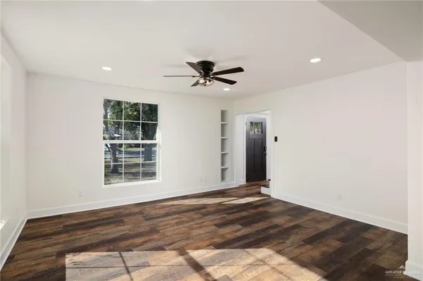 a view of an empty room with a window and a ceiling fan