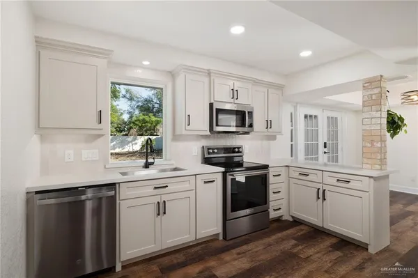 an empty room with wooden floor closet and windows
