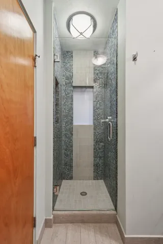 a bathroom with a glass shower door and a sink