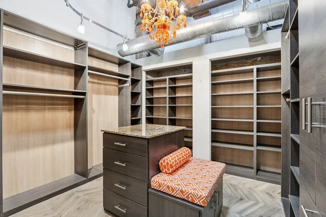 a view of walk in closet and wooden shelves