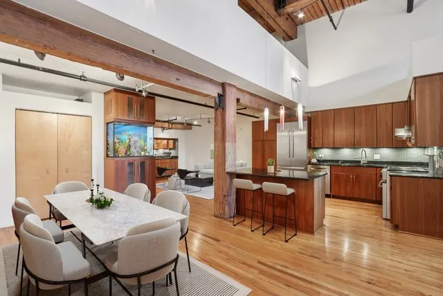 a dining room with wooden floor a glass table and chairs