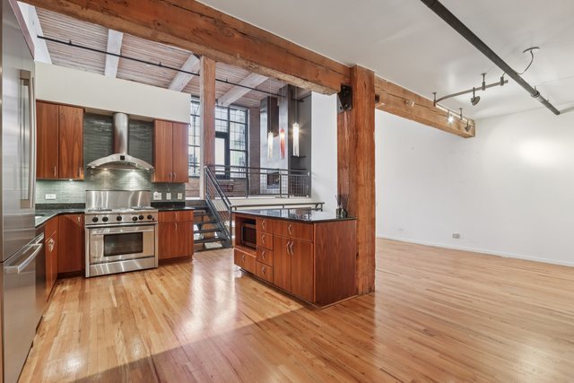 1000 West Washington Boulevard, Unit 137 Chicago, IL 60607 - Photo 8 of 33 a kitchen with stainless steel appliances granite countertop a stove and a wooden floors