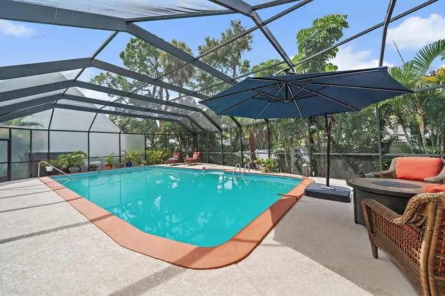 a view of a chairs and table in the patio and a table under an umbrella