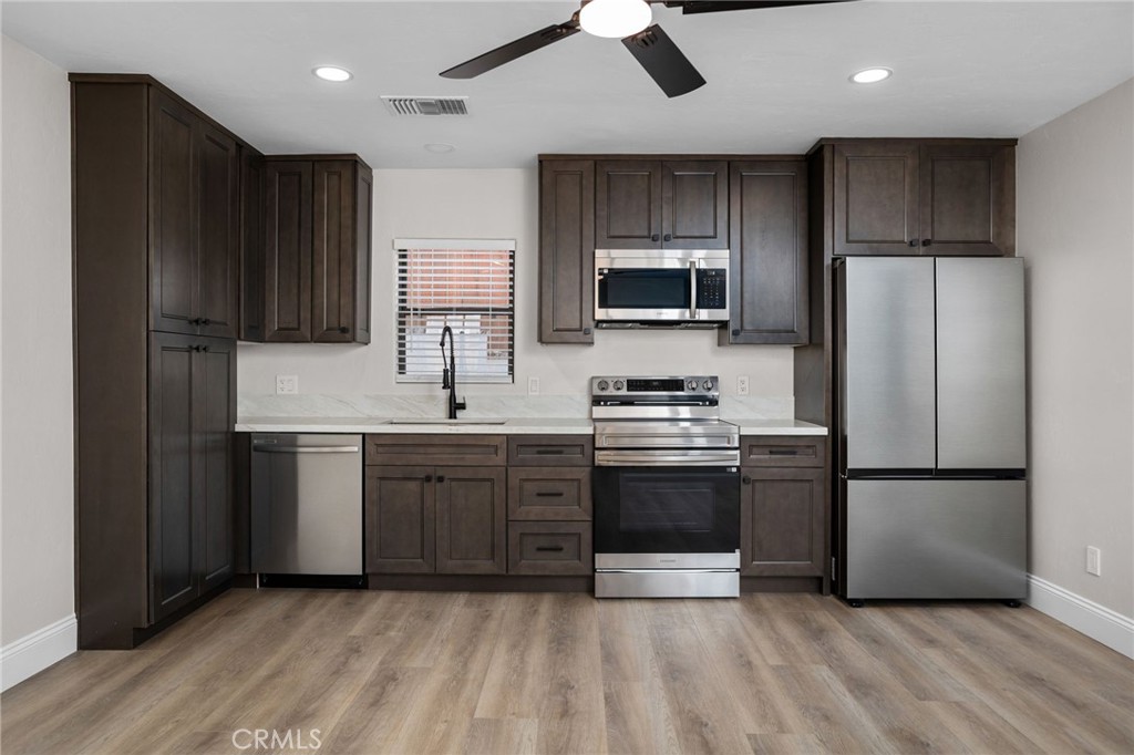 29566 Big Range Road, Unit 2 Canyon Lake, CA 92587 - Photo 11 of 27 a kitchen with stainless steel appliances granite countertop a refrigerator stove a sink and dishwasher