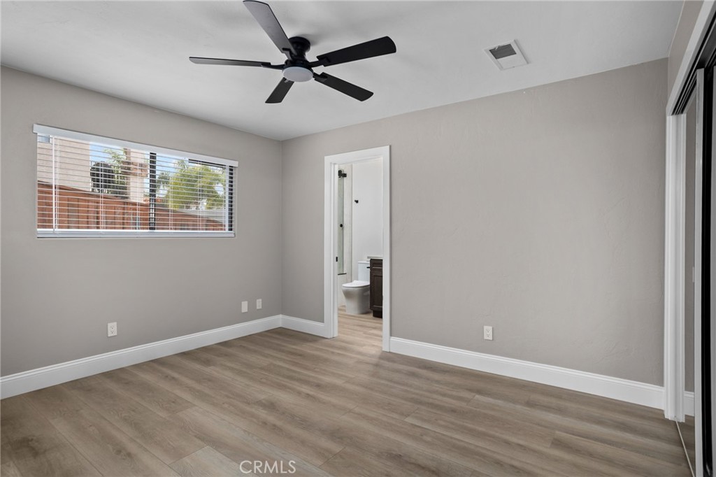 29566 Big Range Road, Unit 2 Canyon Lake, CA 92587 - Photo 12 of 27 an empty room with wooden floor fan and windows