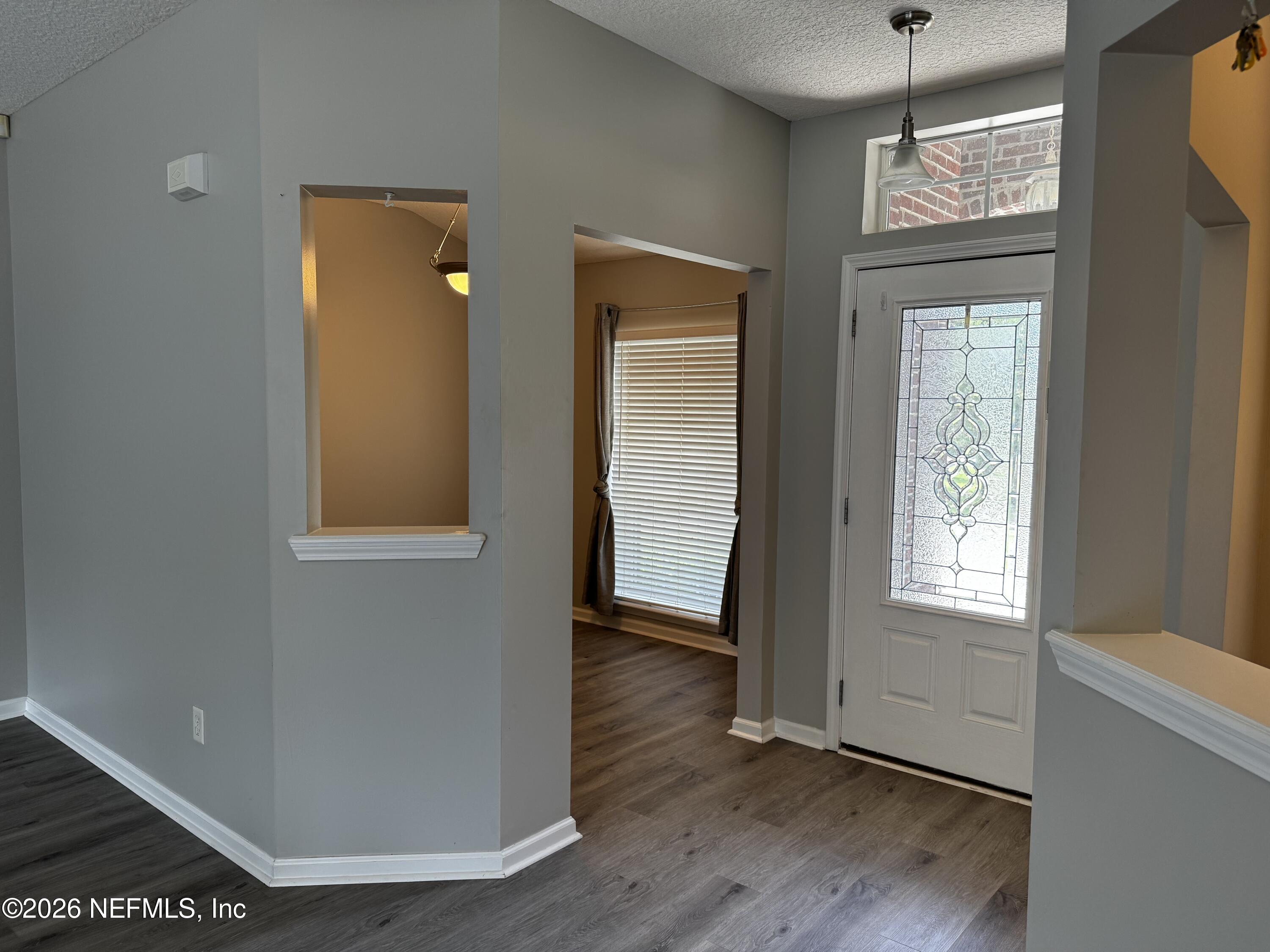 16255 Shellcracker Road Jacksonville, FL 32226 - Photo 7 of 40 a view of an empty room with wooden floor and a window