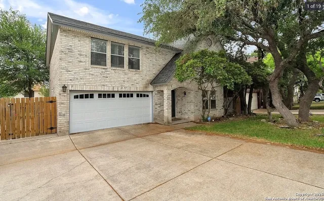 a front view of a house with a garden and trees