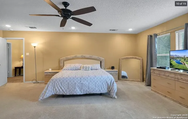 a bedroom with a bed a window and a chandelier