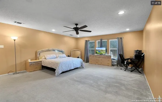 a spacious bedroom with a bed and a chandelier