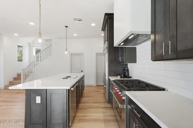 a kitchen with kitchen island a sink stove and refrigerator