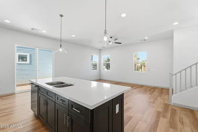 a kitchen that has a sink a stove and a wooden floor