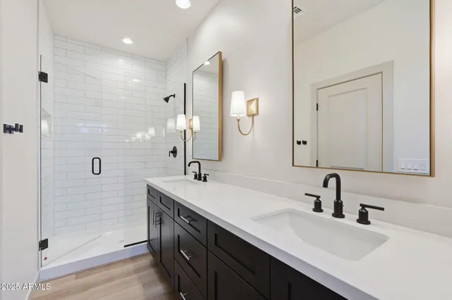 a bathroom with a double vanity sink a mirror and shower