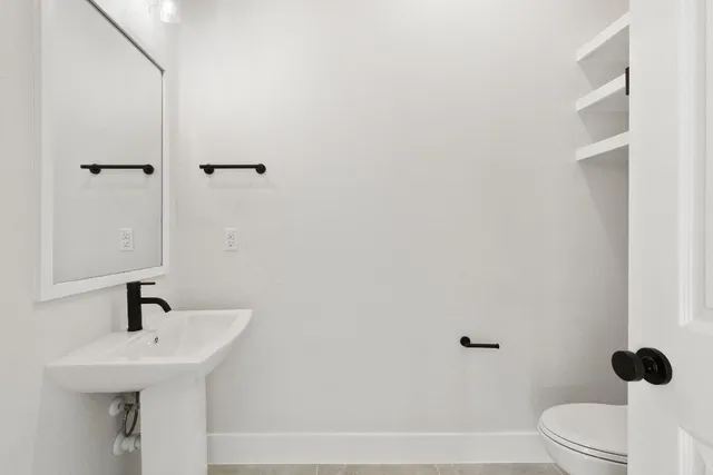 a bathroom with a sink a toilet and a mirror
