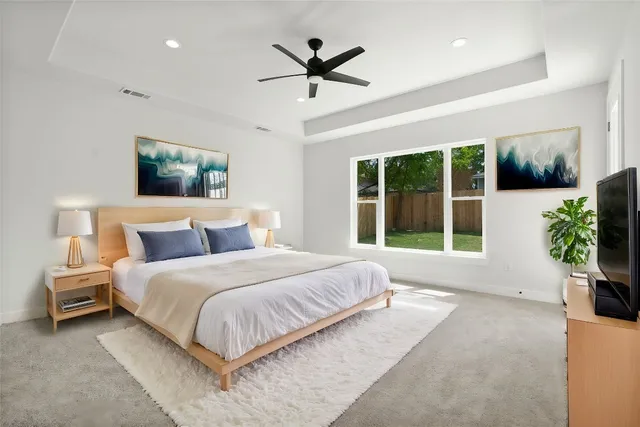 a spacious bedroom with a large bed a chandelier and a large window