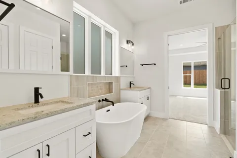 a bathroom with a tub sink and mirror