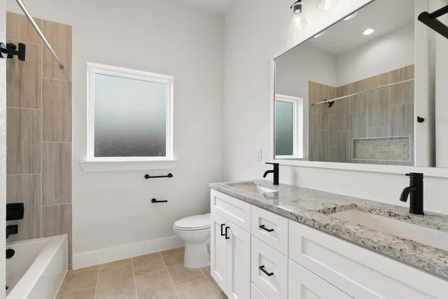 a bathroom with a granite countertop sink mirror and a bathtub