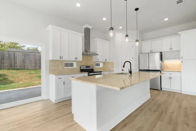 a large kitchen with kitchen island a sink stainless steel appliances and cabinets