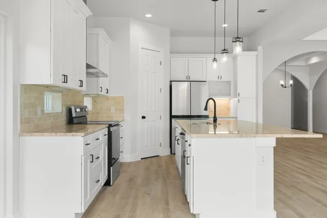 a kitchen with a sink stove and refrigerator