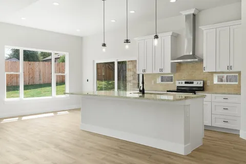 a kitchen with stainless steel appliances granite countertop a stove a sink and a refrigerator