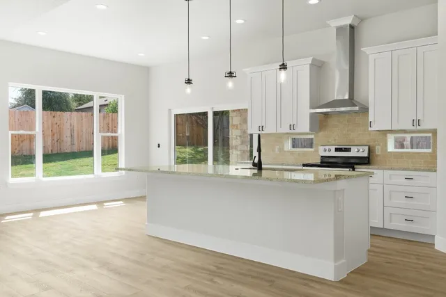a kitchen with stainless steel appliances granite countertop a stove a sink and a refrigerator