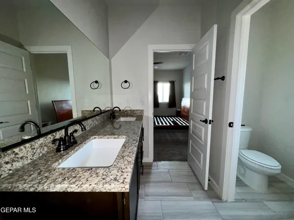 a bathroom with a granite countertop sink and a mirror