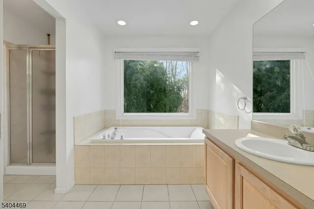 a bathroom with a tub sink and mirror